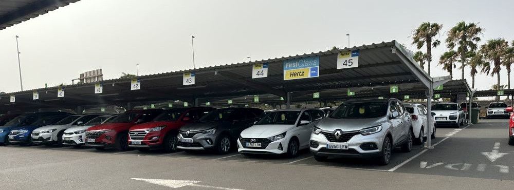 Mietwagen Fahrzeuge von Hertz stehen auf dem Parkplatz unter einem Dach