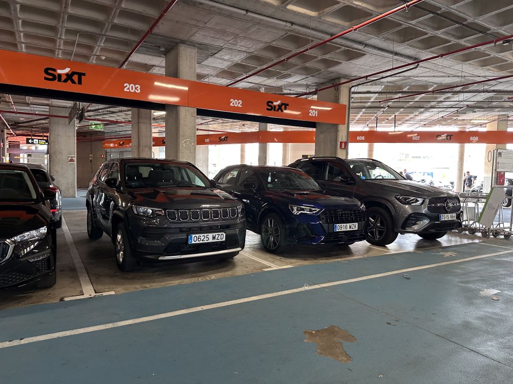 Sixt Mietwagenparkplätze mit Jeep, Audi und Mercedes Modellen direkt am Terminal.